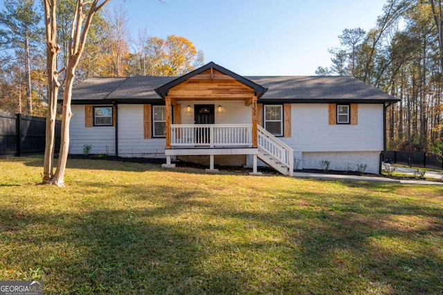 ranch-style home featuring covered porch and a front lawn