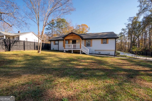 rear view of property featuring a lawn