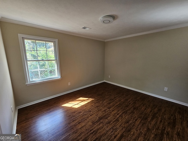 empty room featuring dark hardwood / wood-style flooring and ornamental molding