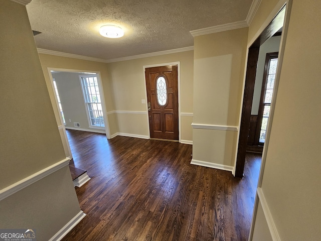 entrance foyer with dark hardwood / wood-style flooring, ornamental molding, and a textured ceiling