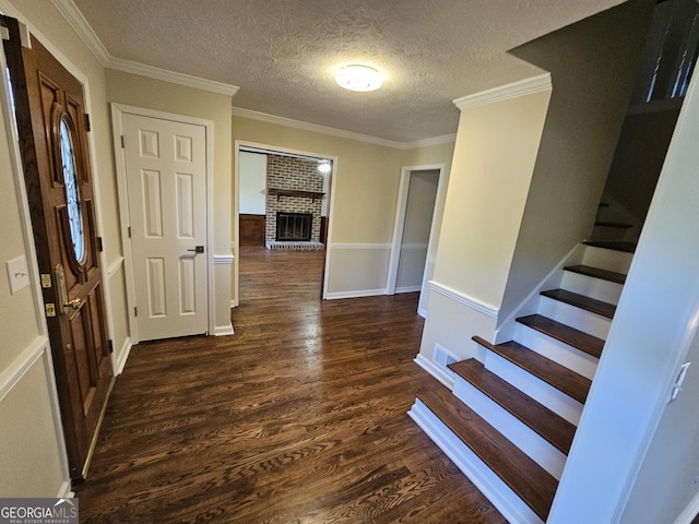 interior space with a textured ceiling, dark hardwood / wood-style flooring, and crown molding