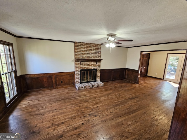 unfurnished living room with a wealth of natural light, dark hardwood / wood-style flooring, crown molding, and a textured ceiling