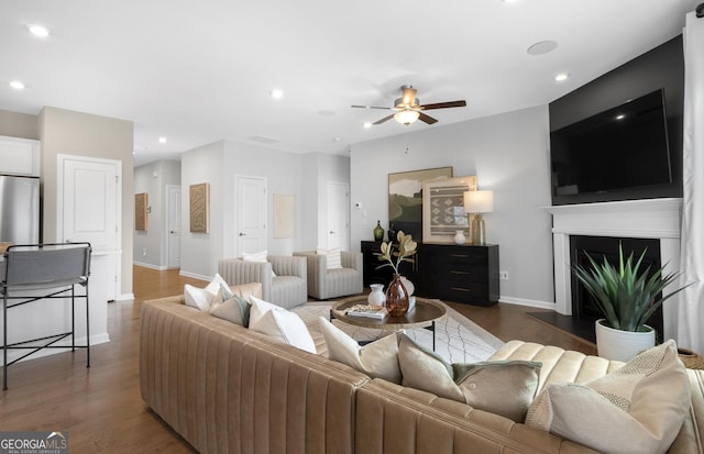 living room featuring ceiling fan and dark wood-type flooring