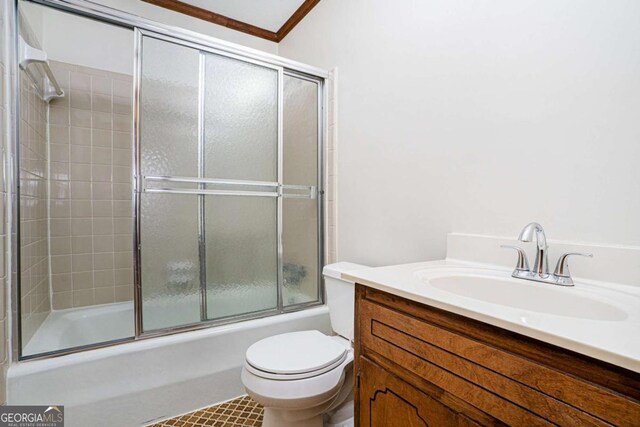 full bathroom with shower / bath combination with glass door, toilet, vanity, and ornamental molding