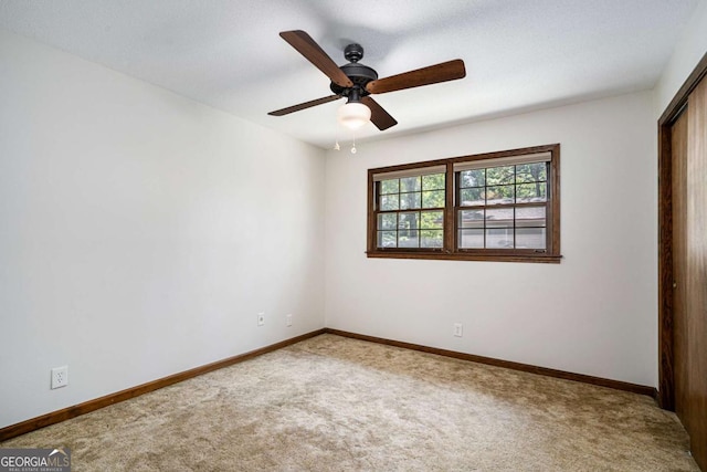 unfurnished room featuring a textured ceiling, carpet floors, and ceiling fan