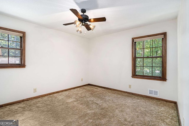 carpeted spare room featuring ceiling fan