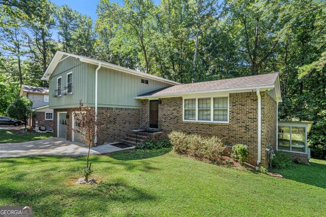 split level home featuring a garage and a front lawn