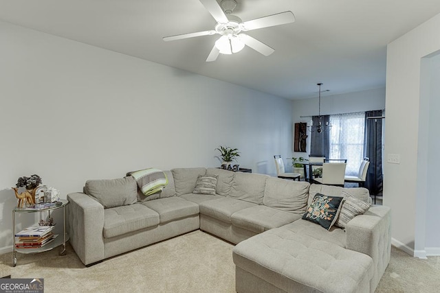 carpeted living room with ceiling fan with notable chandelier