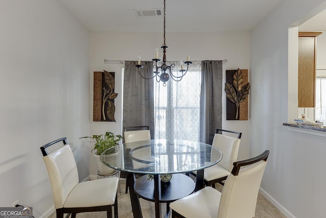 carpeted dining area featuring a healthy amount of sunlight and an inviting chandelier