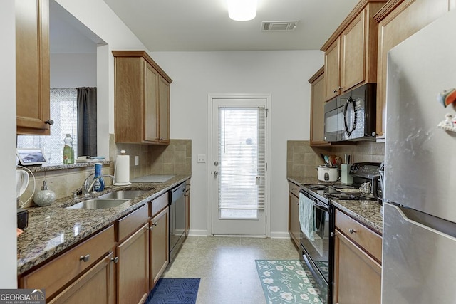 kitchen featuring backsplash, sink, black appliances, and stone countertops