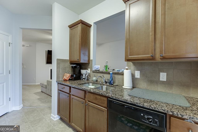 kitchen featuring dishwasher, sink, dark stone counters, and tasteful backsplash