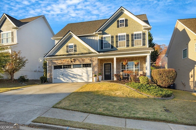 craftsman-style home featuring covered porch, a garage, and a front lawn