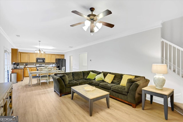 living room featuring light hardwood / wood-style flooring, ceiling fan with notable chandelier, and ornamental molding