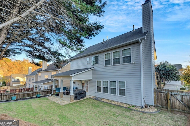 rear view of house featuring a lawn and a patio