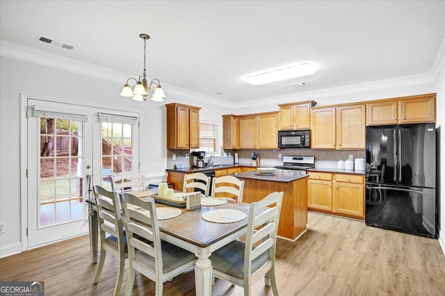 kitchen with black appliances, crown molding, sink, light wood-type flooring, and decorative light fixtures