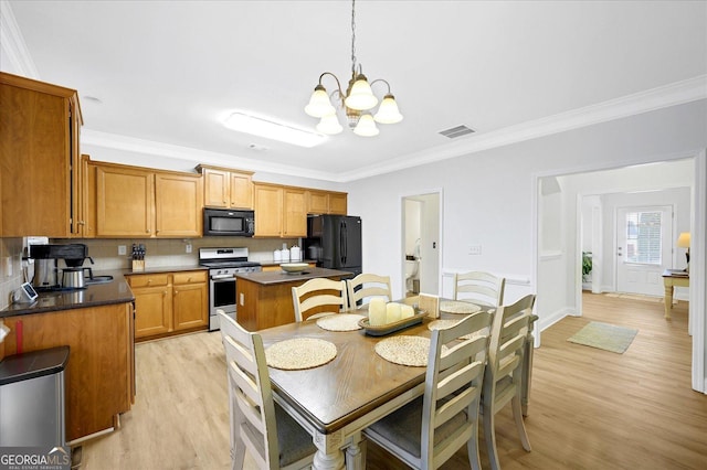 dining space featuring light wood-type flooring, ornamental molding, and an inviting chandelier