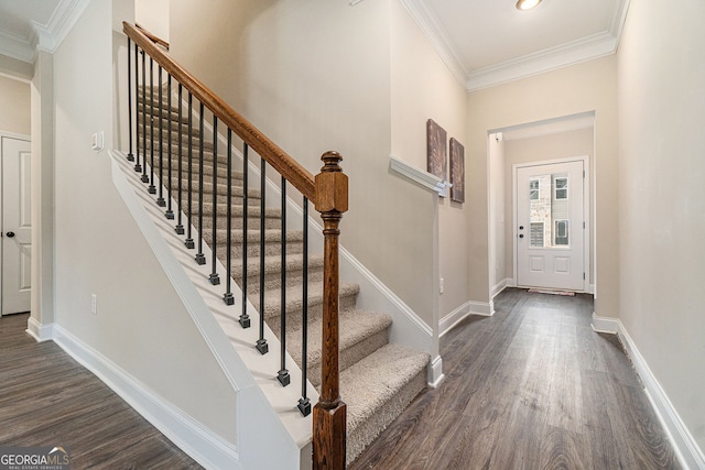 foyer with dark wood-type flooring and ornamental molding