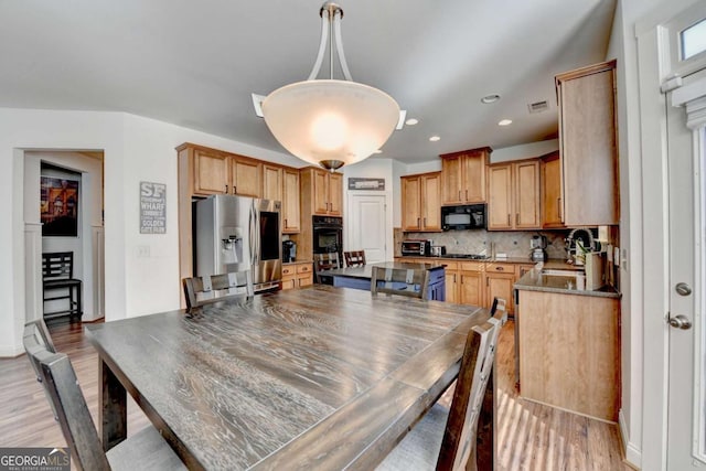 dining room featuring sink and light hardwood / wood-style flooring