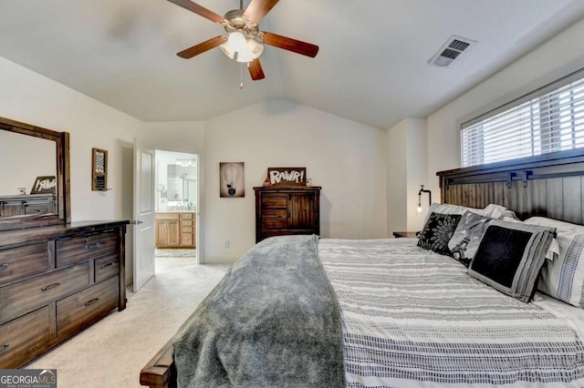 carpeted bedroom with ensuite bathroom, vaulted ceiling, and ceiling fan