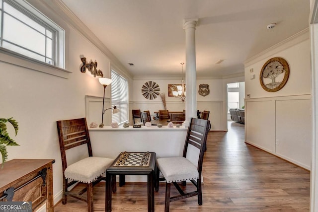 interior space with hardwood / wood-style floors, ornamental molding, and decorative columns