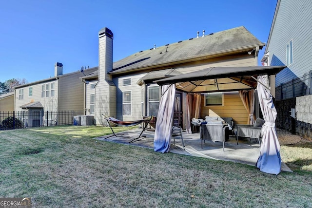 rear view of property with a gazebo, a patio area, a lawn, and central AC