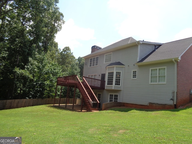 rear view of house with a lawn, a patio area, and a deck