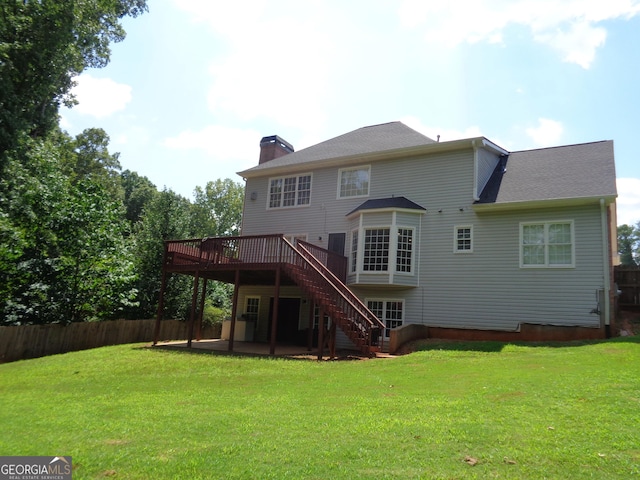 back of property with a lawn and a deck