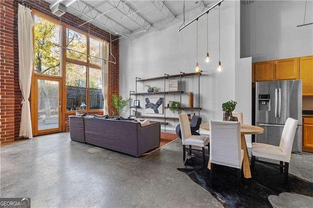 interior space featuring a high ceiling and brick wall