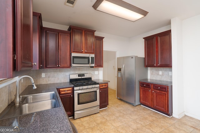 kitchen with appliances with stainless steel finishes, tasteful backsplash, and sink