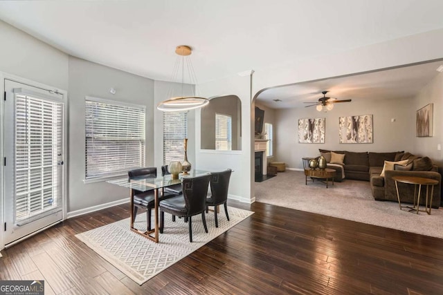 dining area with ceiling fan and dark wood-type flooring