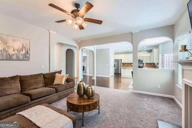 carpeted living room with ceiling fan and sink