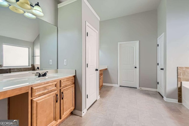 bathroom with a tub, vanity, and vaulted ceiling