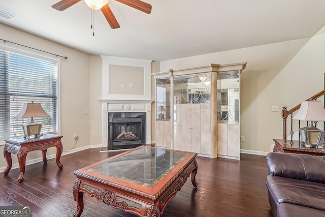 living room featuring dark hardwood / wood-style flooring, ceiling fan, and plenty of natural light