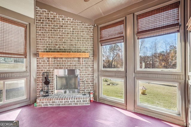 unfurnished sunroom featuring lofted ceiling and a fireplace