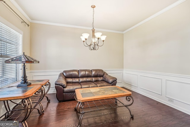 living room with a notable chandelier, crown molding, and dark wood-type flooring