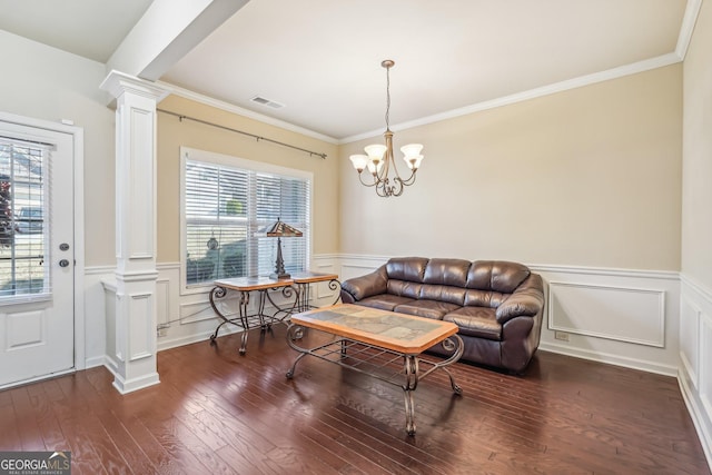 interior space featuring dark hardwood / wood-style floors, an inviting chandelier, decorative columns, and a healthy amount of sunlight