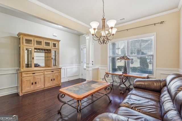 living room with a notable chandelier, dark hardwood / wood-style flooring, and ornamental molding