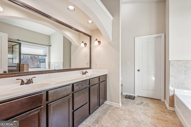 bathroom featuring vanity and a washtub