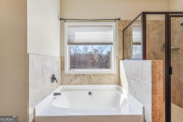 bathroom featuring shower with separate bathtub