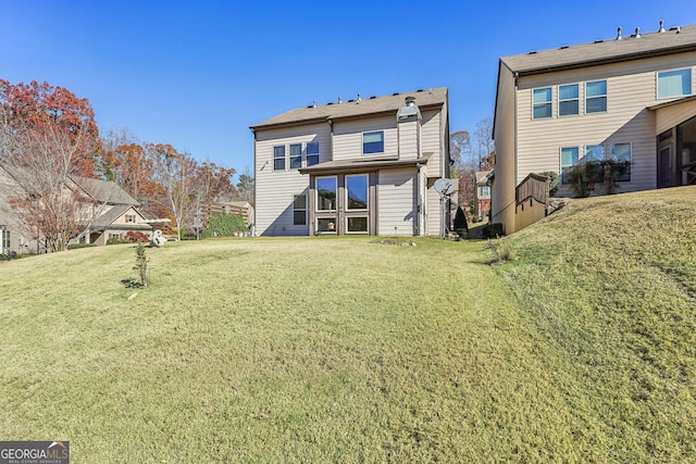 rear view of house featuring a lawn