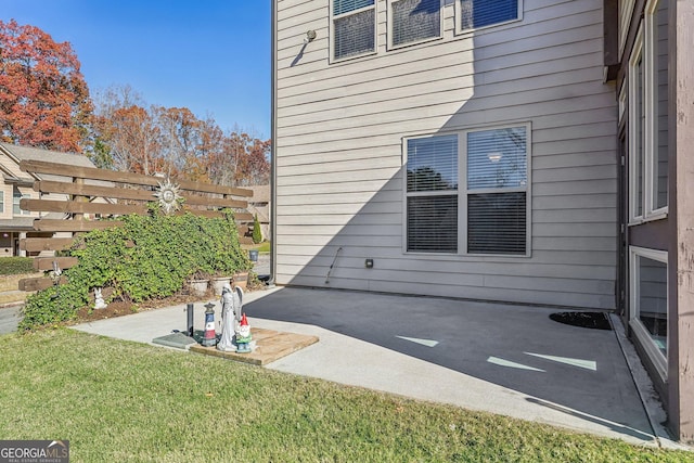 view of side of home with a lawn and a patio area