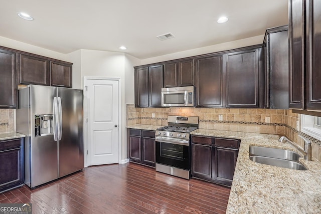 kitchen with dark wood-type flooring, decorative backsplash, sink, and stainless steel appliances