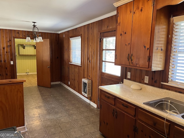 kitchen with heating unit, decorative light fixtures, and wooden walls