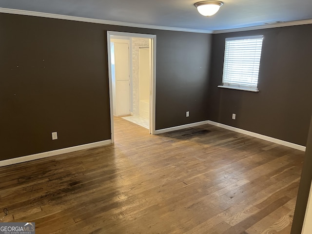 unfurnished room featuring ornamental molding and wood-type flooring