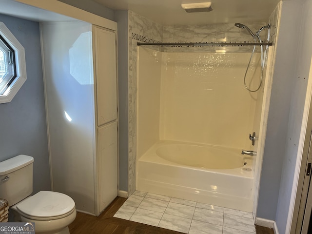 bathroom featuring toilet and tiled shower / bath combo