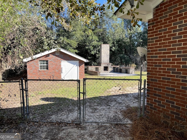 view of gate featuring a fireplace and a lawn