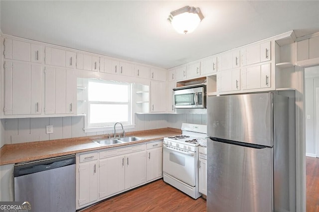 kitchen with white cabinets, sink, stainless steel appliances, and light hardwood / wood-style flooring