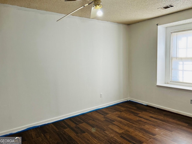 empty room featuring a textured ceiling, dark hardwood / wood-style flooring, and ceiling fan