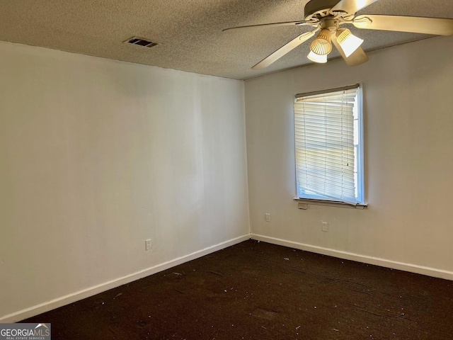 carpeted spare room with a textured ceiling and ceiling fan