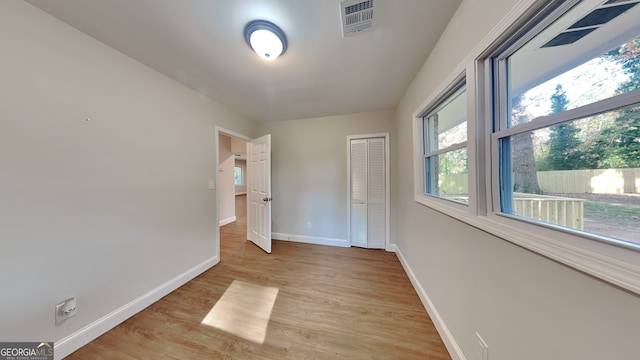 unfurnished bedroom featuring a closet and light hardwood / wood-style flooring